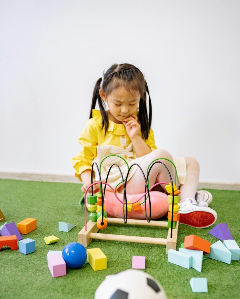Child solving puzzle on green rug